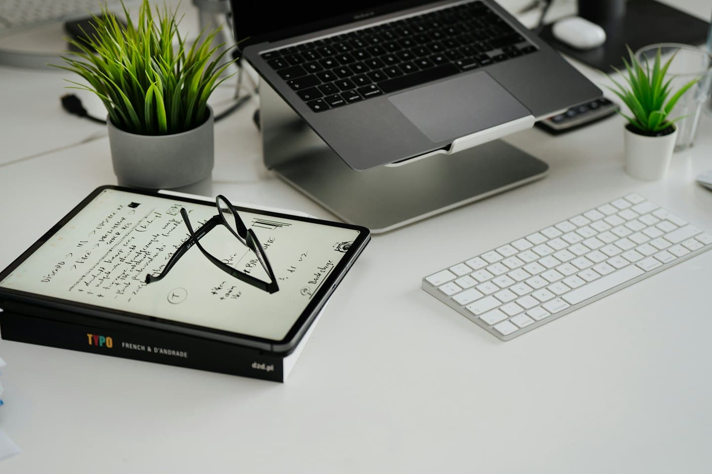 Computer portatile e tablet su una scrivania moderna, pulita e ordinata.